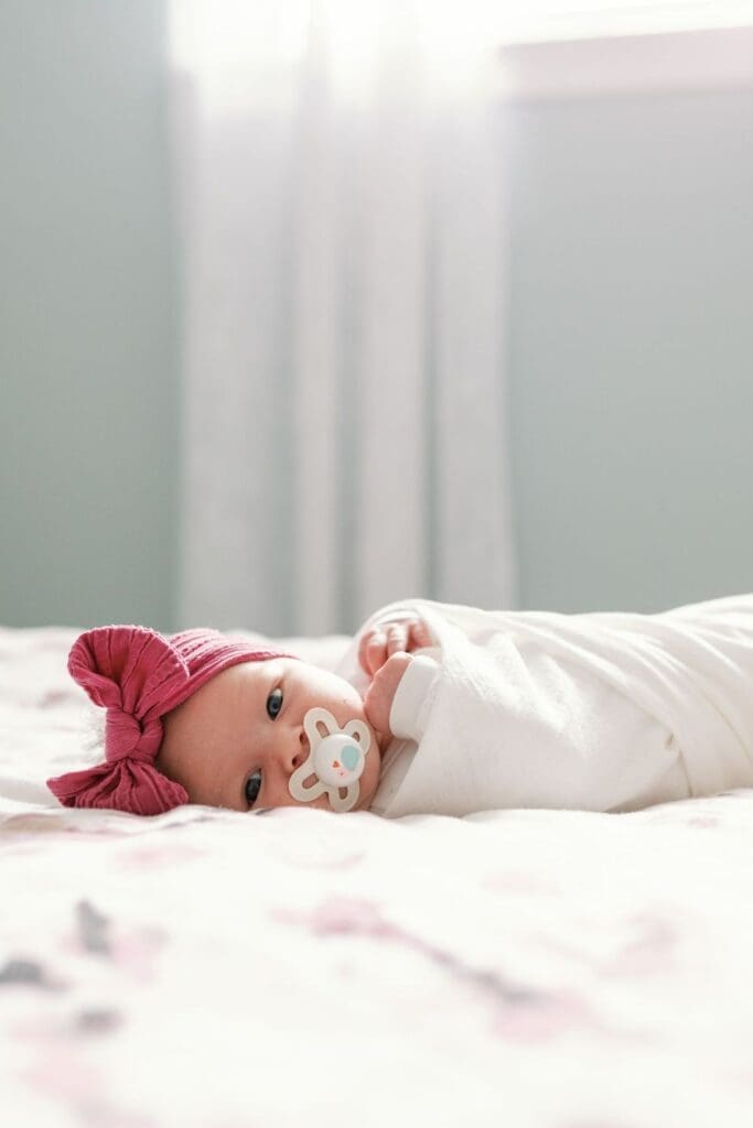 Close-up of a newborn baby lying on a white textured blanket, peacefully resting.