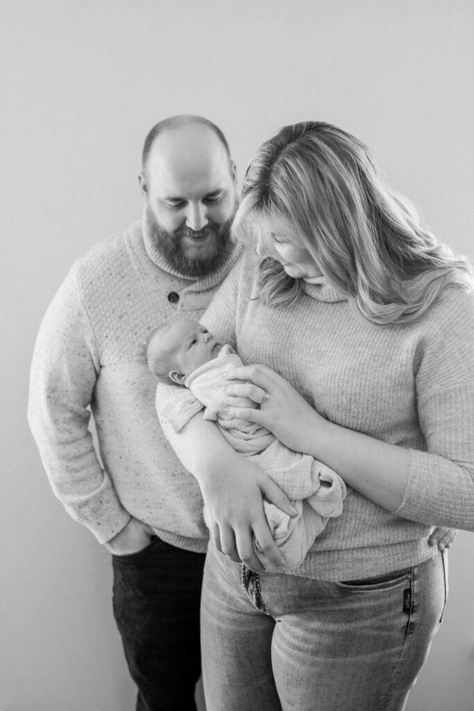 Black and white image of new parents holding their newborn daughter