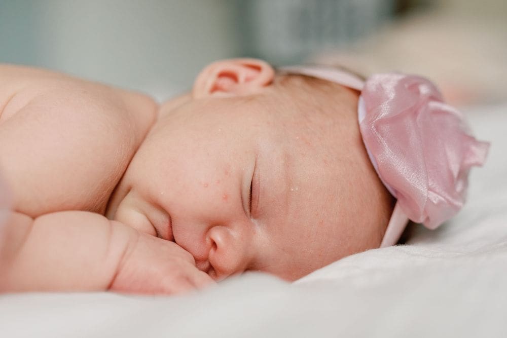 Close-up image of newborn baby girl’s peaceful face as she sleeps