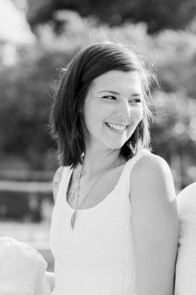Woman smiling in natural light during family session at Burlington Botanical Gardens.