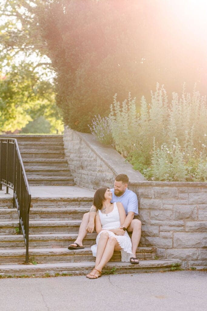 Couple sitting on stone garden steps bathed in warm sunset light.