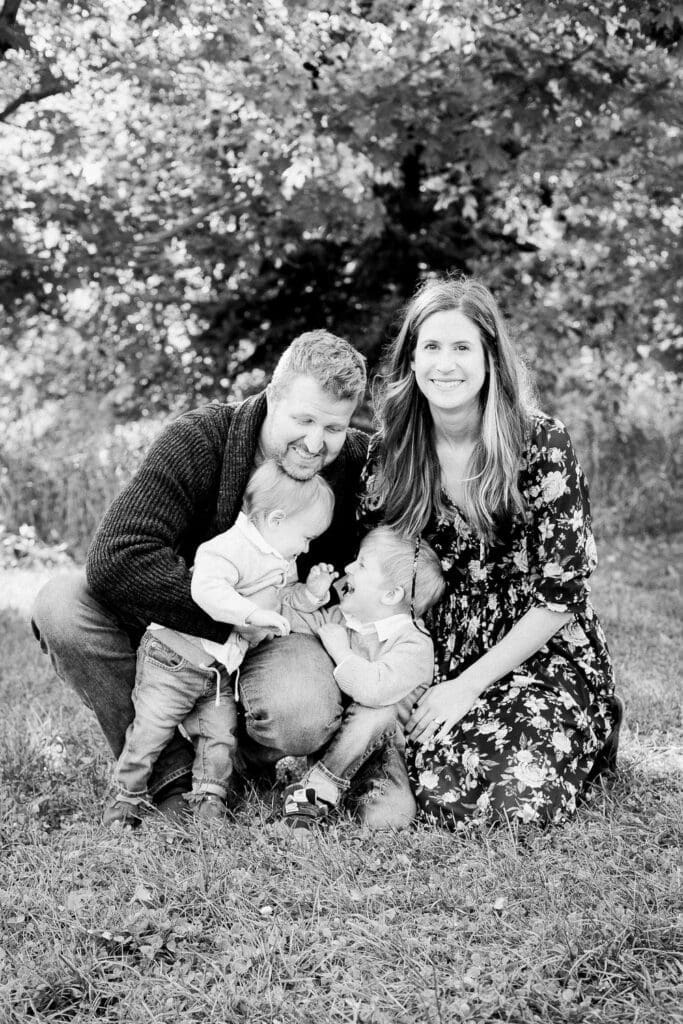 Family laughing together while sitting on the grass during a lifestyle fall photo session