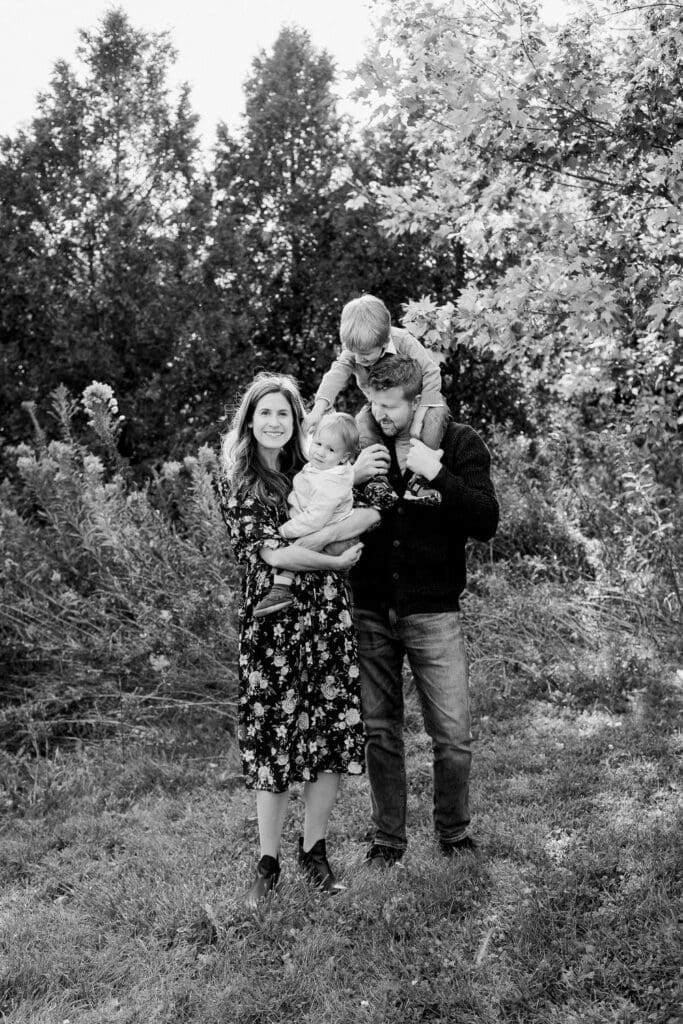 Black and white photo of parents holding their children under a tree during a fall family session