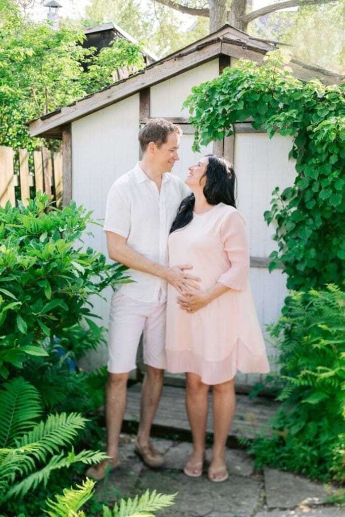 Couple smiling at each other in front of a garden shed
